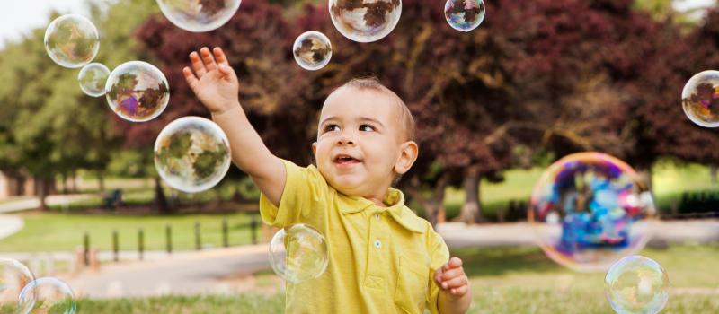 child reaching for bubbles
